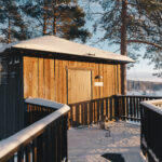 Blick auf eine Hütte mit einem Hund davor © Granö Beckasin