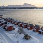Die Rorbuer des Malangen Resorts am verschneiten Fjord © Malangen Resort